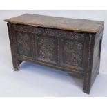 A 17thC oak coffer, with a plank top above a carved frieze and three panels on stiles, adapted,
