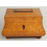 A bombe sarcophagus shaped burr elm tea caddy, the hinged lid revealing a sectional interior set