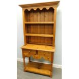 A small reproduction pine dresser, with two plate shelves, the base with an arrangement of two