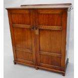 An early to mid 20thC mahogany small compactum type wardrobe, with a raised back, the top with a