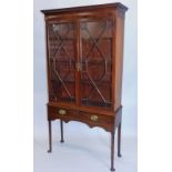 A mahogany bookcase, the top with a dentil cornice above two astragal glazed doors, the associated