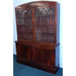 A 19thC mahogany bookcase, the top with a bowed cornice, above two glazed doors, with gothic