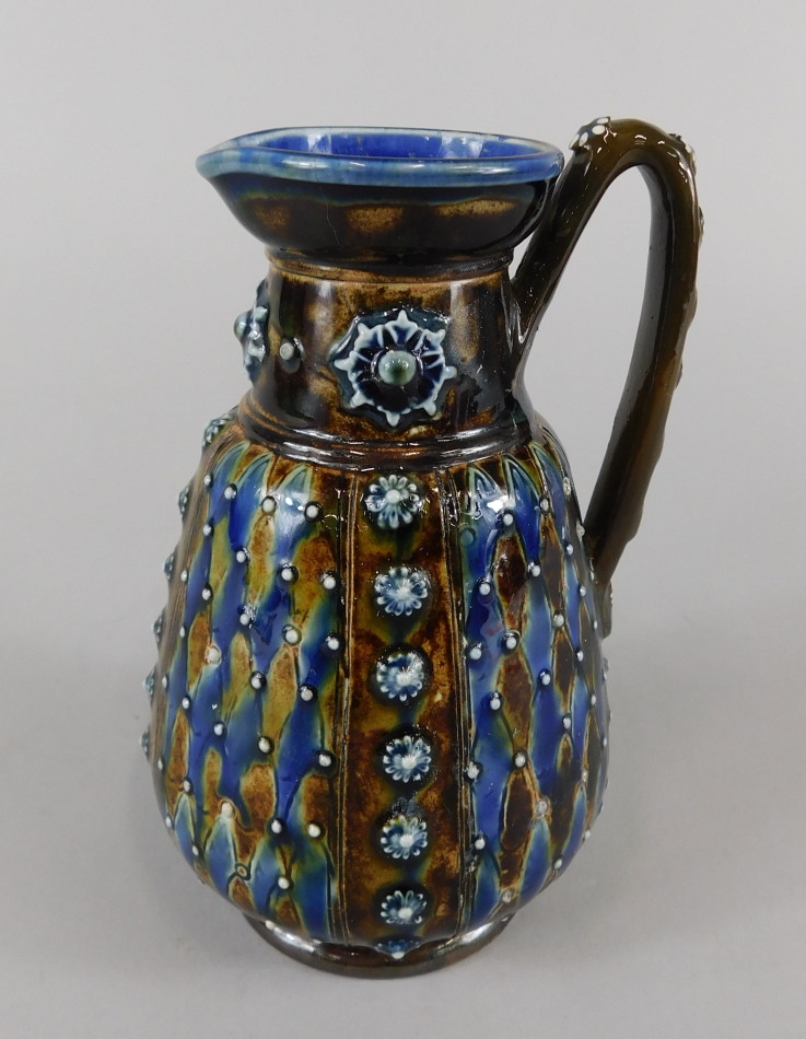 A Doulton Lambeth Studio type jug, decorated with lozenges and raised roundels, impressed marks to