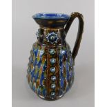 A Doulton Lambeth Studio type jug, decorated with lozenges and raised roundels, impressed marks to