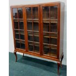 A 20thC mahogany bookcase, with three glazed doors, on cabriole legs, 122cm wide (M)