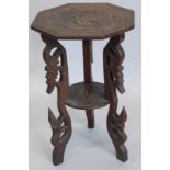 An early 20thC carved hardwood two tier table, with octagonal top on pierced supports, 41cm wide.