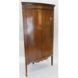 A 19thC mahogany bow fronted corner cabinet, with a Greek key carved frieze, on lozenge shaped