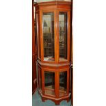 A Bevan and Funnell mahogany display cabinet, of canted form with two glazed doors, on bracket feet,