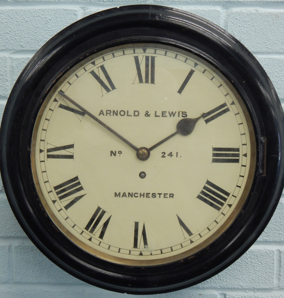 A late 19thC ebonised railway wall clock, the dial signed Arnold & Lewis, Manchester, number 241,