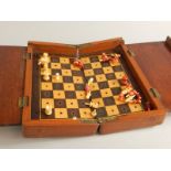 A Victorian travelling chess set, in a hardwood case with bone pieces, 20cm wide.