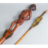 A Tribal figural spear staff, with shaped hourglass end, and nude pommel and an arrow 116cm wide.