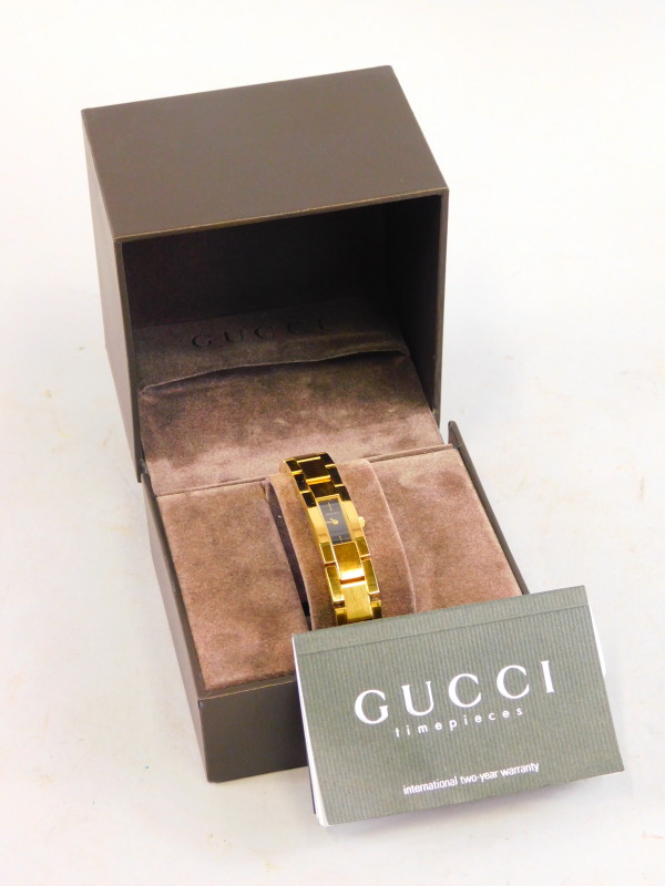 A Gucci gold plated ladies wristwatch, in a fitted case, original retailers card for Fenton Hill