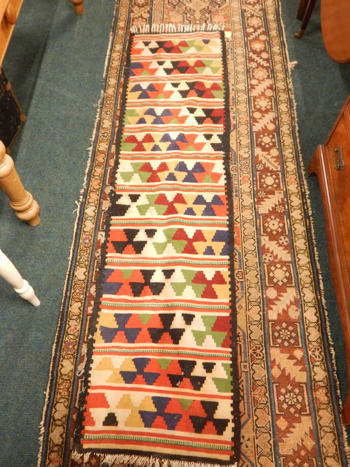 A Persian runner, with an all over design, on a pink ground, with multiple borders 380cm x 90cm