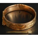 A 9ct gold bangle and a stick pin, the bangle with floral decoration, and inscription N.Storr TNJP