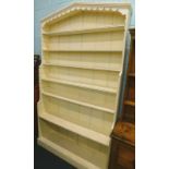 A Victorian painted pine bookcase, with an arched top above adjustable shelves, on plinth base,