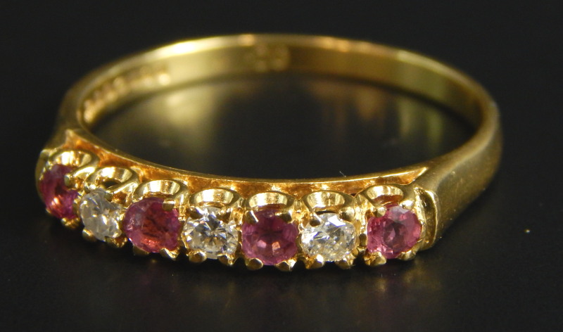 An 18ct gold ruby and diamond dress ring, set with four rubies and three diamonds, 3.1g all in.