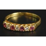 An 18ct gold ruby and diamond dress ring, set with four rubies and three diamonds, 3.1g all in.