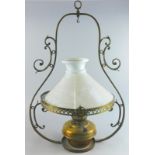 An early 20thC brass hanging lantern, with milk glass shade, of shaped outline, 72cm high.