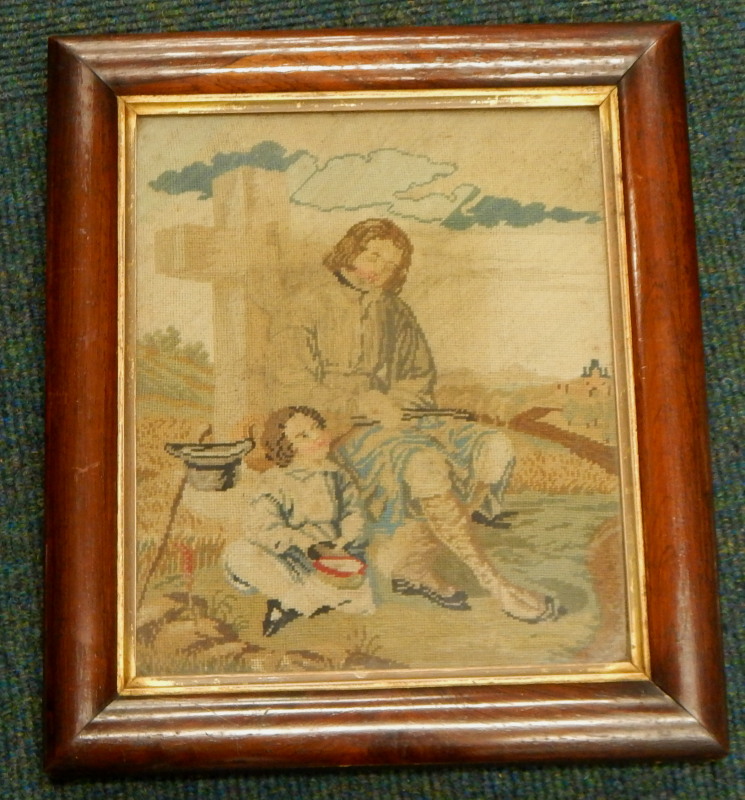 A 19thC woolwork picture, depicting a figure beside a cross, with a young child, two prints of