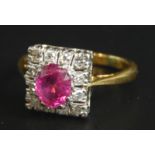 An Art Deco dress ring, set with central ruby, surrounded by tiny diamonds, on yellow metal band,