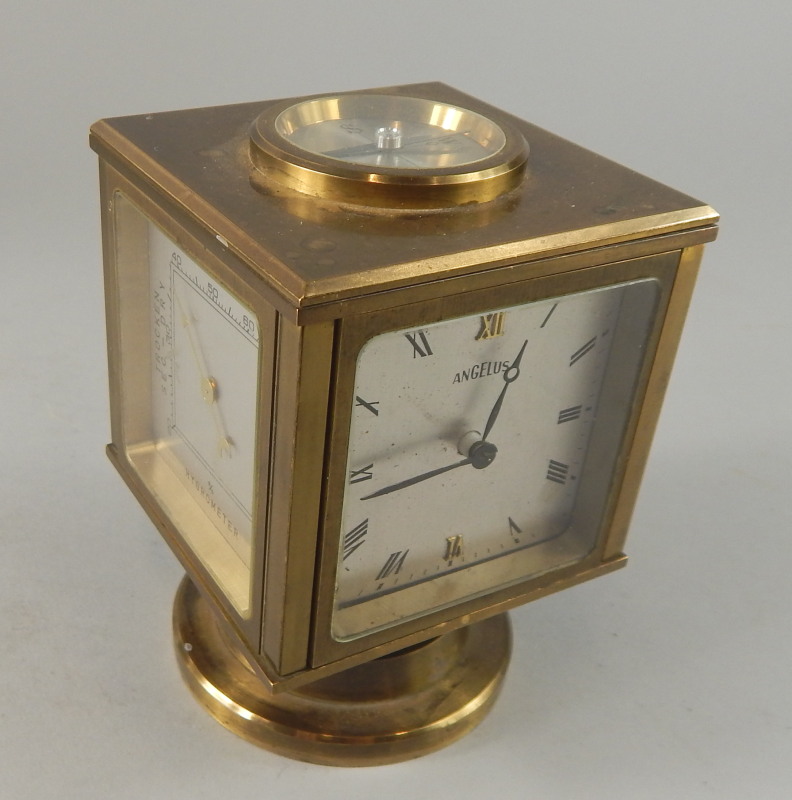 An Angelus brass barometer and mantel timepiece, with four silvered dials, on a swivel base