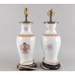 A pair of oriental style lamp bases, each decorated with an armorial of flowers, etc, sold with