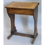 An early 20thC oak child's school desk, with slope hinged top, shaped end supports, 66cm wide.