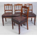 A set of four Victorian walnut dining chairs, each with spindle turned back and padded seat.