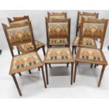 A set of six Art Nouveau style oak dining chairs, each with a carved and shaped high back, a