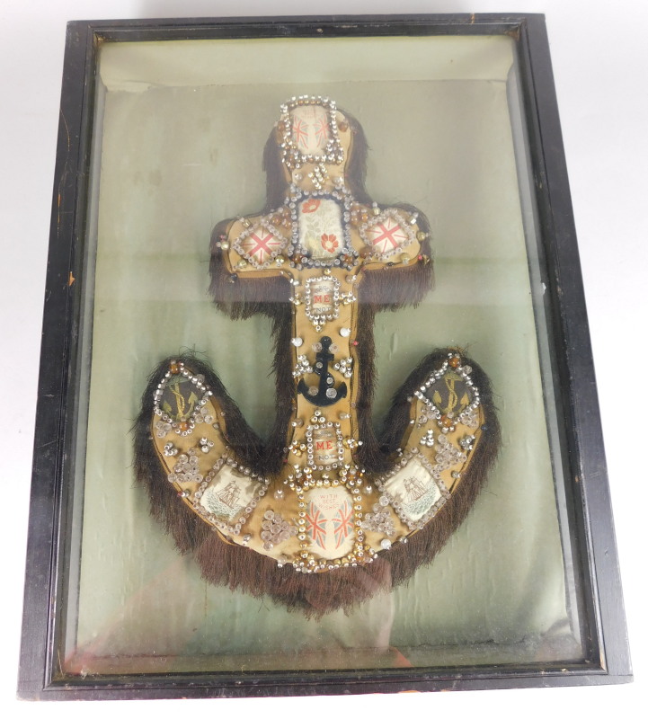 An early 20thC nautical anchor shaped pin cushion, applied with Stevenographs, beads etc., in fitted