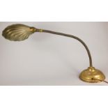 An early 20thC lacquered brass adjustable desk lamp, with shell shaped shade and domed foot, the