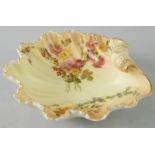 A Royal Worcester porcelain shell shaped dish, painted with flowers, on a blush ivory ground,