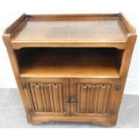 An Old Charm style oak side cabinet, with a recess, above two linen fold carved doors