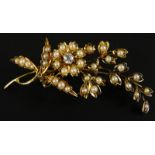 A Victorian floral spray brooch, set with seed pearls and a tiny diamond, in the form of a flower