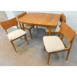 A retro style 1970's teak extending dining table and four chairs.The upholstery in this lot does not