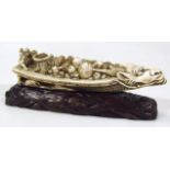 A Japanese carved and stained okimono figure group, of musicians in a dragon boat, signature to