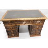 A Victorian oak pedestal desk, carved overall with foliate scrolls, masks, etc, the rectangular