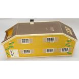 A 1980's/90's retro style plastic and painted card dolls house