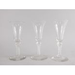 Three wine glasses in 18thC style, each with a bell shaped bowl and a fine air twist stem