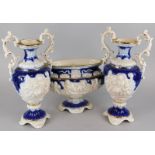 An Italian pottery garniture, moulded with putti, nude females, etc., on a cobalt blue ground,