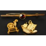 A 9ct gold garnet set bar brooch, and two gold plated charms.