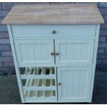 A modern light beech kitchen unit, with drawers and cupboards above wine rack