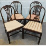 A set of four mahogany dining chairs in George III style, each with a pierced splat, carved with