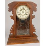 An American Ansonia clock company oak mantel clock, with paper dial, the arched door with a verre