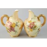 A pair of Royal Worcester porcelain ewers, each painted with flowers on a blush ivory ground, picked