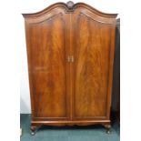 A mahogany wardrobe, with a shaped top, with two doors, on short shell carved cabriole legs, 126cm