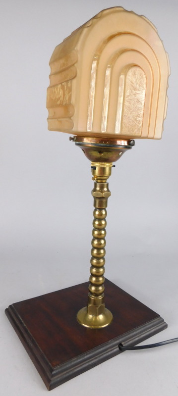 An Art Deco style brass table lamp, with part frosted glass shade and later mahogany plinth, 48cm