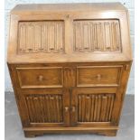 An Old Charm style type oak bureau, carved with linen folds etc., 76cm wide