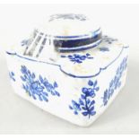 An 18thC faience blue and white pottery inkwell, decorated with flowers, the compressed square