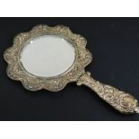 A late Victorian silver mounted hand mirror, with a circular bevel plate and red leather backing,
